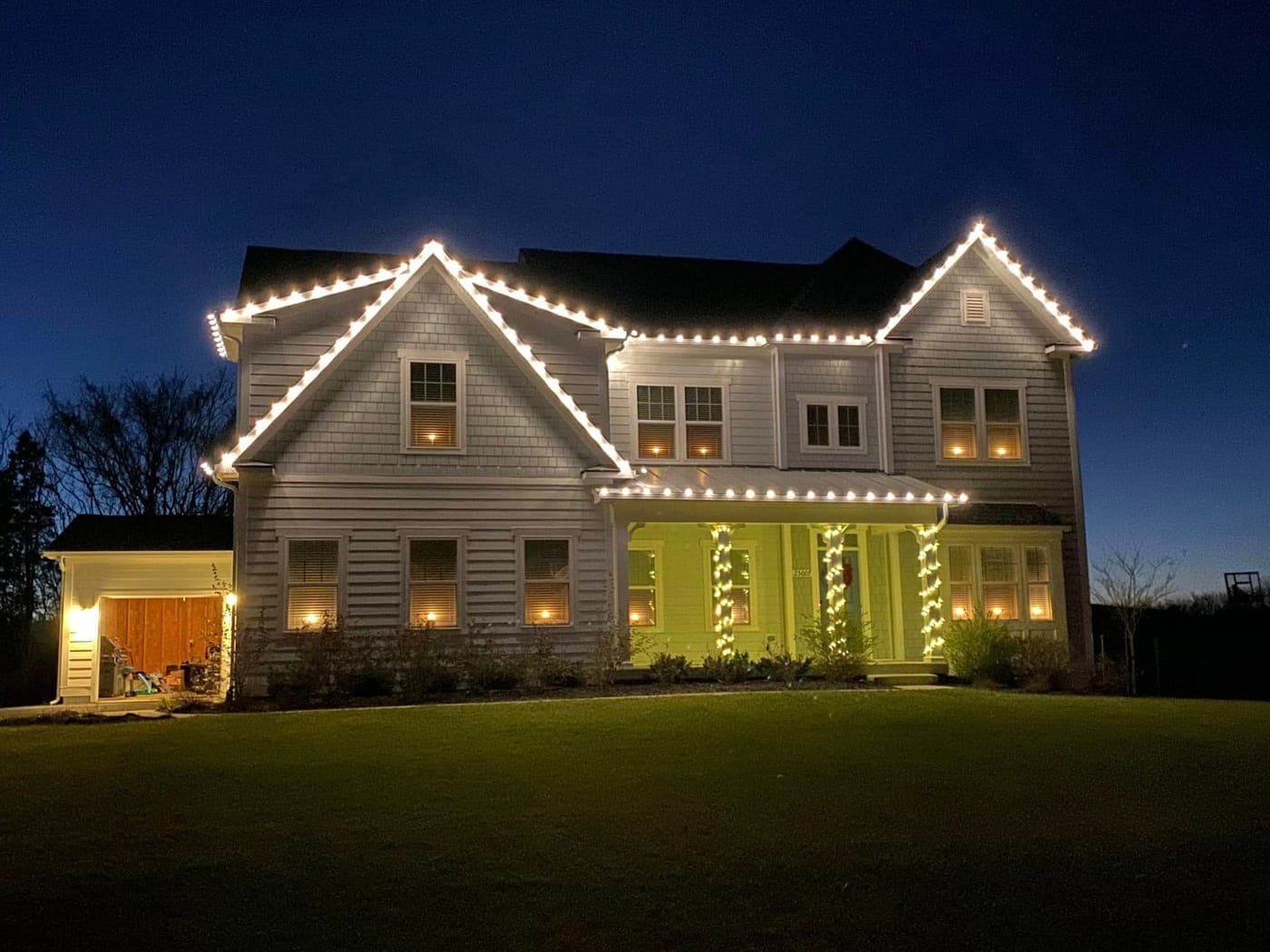 Warm-white roofline Christmas lights at dusk on a Southern Maryland home
